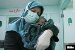 Egy szülésznő egy újszülöttel egy teheráni kórházban