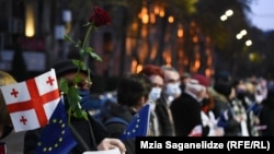 People wave Georgian and EU flags -- and roses -- to mark the anniversary of the Rose Revolution in Tbilisi in 2021.