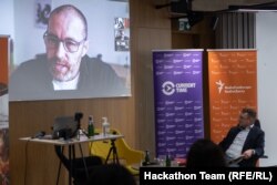 Political scientist Thomas Rid (screen), speaking with RFE/RL's Pete Baumgartner (r) and participants in the 2021 RFE/RL Hackathon in Prague