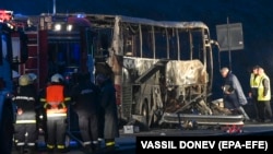 Firefighters, police, and investigators inspect the wreckage of the bus near the village of Bosnek, Bulgaria, on November 23.