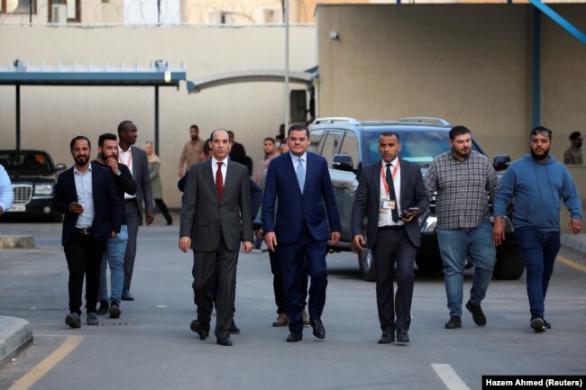 عبدالحميد الدبيبه (وسط) نخست‌وزیر لیبی به هنگام حضور در مرکز ثبت نام طرابلس برای اعلام نامزدی در انتخابات