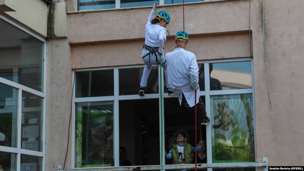 Dy alpinistë duke u lëshuar me litarë në Klinikën e Pediatrisë në Prishtinë.