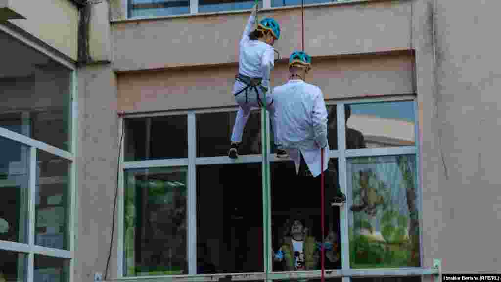 Dy alpinistë duke u lëshuar me litarë në Klinikën e Pediatrisë në Prishtinë.&nbsp;