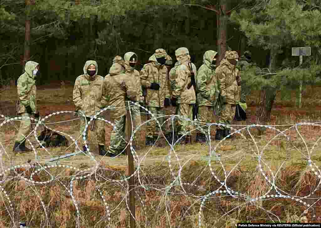 Сілавікі патрулююць мяжу ў той момант, калі сотні мігрантаў спрабуюць нелегальна перайсьці яе. 8 лістапада 2021