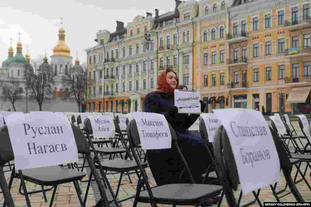 An activist attends a performance called Free Chairs on a square near the St. Sophia Cathedral in Kyiv. The performance was in support of Ukrainian political prisoners in Russia, Crimea, and the eastern Ukrainian conflict zone. A free chair symbolizes a person who cannot attend an act as a result of an arrest, disappearance, or killing.