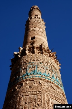 A view from beneath the minaret highlighting its Islamic script and detailed brickwork.