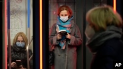 People wearing face masks to protect against the coronavirus travel on a train in Moscow's subway. (file photo). 