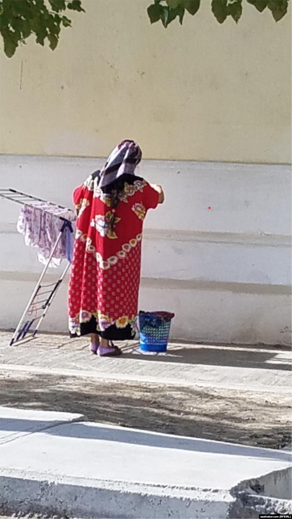 Ýuwlan geýim-eşikleri serýän aýal. Aşgabat, noýabr, 2021.