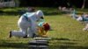 A cemetery worker puts flowers on the grave of a person, who died of the coronavirus disease in San Salvador, El Salvador November 2, 2021. 