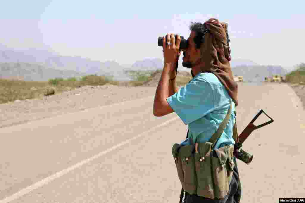 Боец, лояльный правительству Йемена, которое поддерживает Саудовская Аравия, смотрит через бинокль в сторону повстанцев-хуситов, за которыми стоит Иран. Провинция Ходейда, 21 ноября 2021 года. Это один из свежих снимков с линии фронта в западной части Йемена&nbsp;