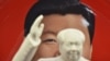 A decorative plate featuring an image of Chinese President Xi Jinping is seen behind a statue of late communist leader Mao Zedong at a souvenir store next to Tiananmen Square in Beijing.