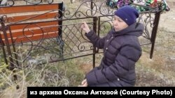 Оксана Аитова показывает, как полицейские пристегивали ее наручниками к ограде на кладбище