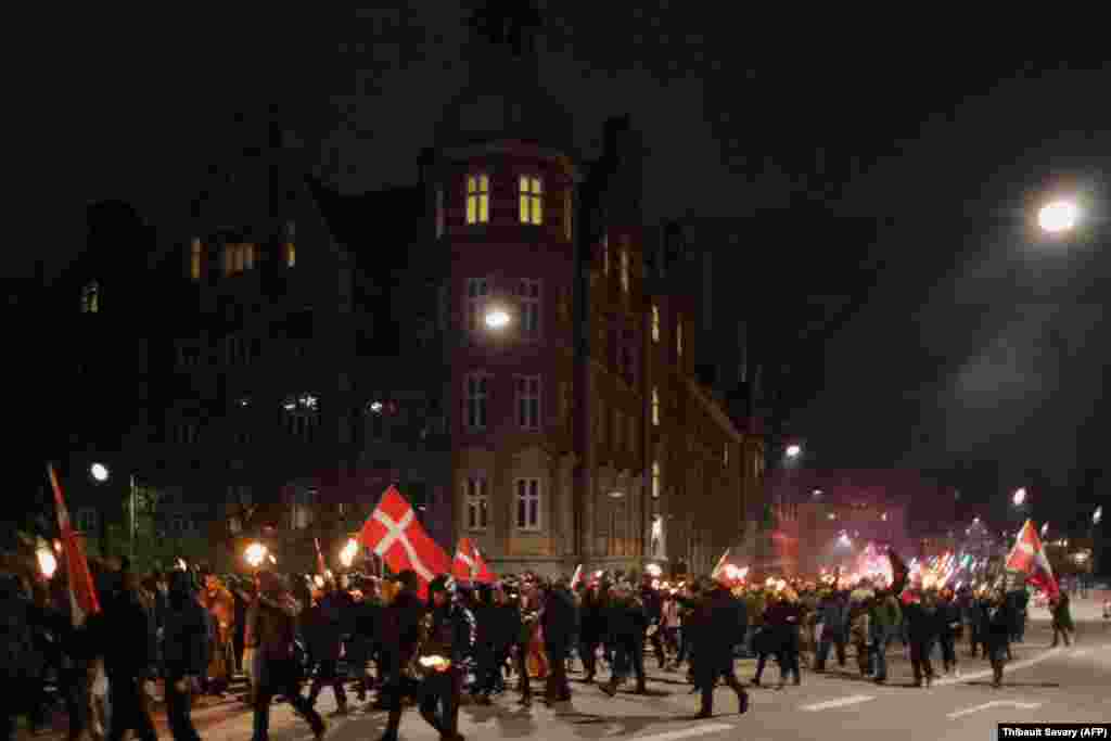 Demonstruesit duke marshuar në mënyrë paqësore gjatë një proteste në Kopenhagë, kundër kufizimeve të reja të caktuara nga qeveria e Danimarkës, për të luftuar pandeminë e COVID-19. (20 nëntor)