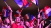 A Nemzeti Tömörülés támogatói francia zászlókat lobogtatnak, miközben a volt pártelnök, Marine Le Pen beszédet mond a parlamenti választások első fordulója után Hénin-Beaumont-ban, Észak-Franciaországban 2024. június 30-án