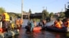 RUSSIA -- Members of the Russian Emergencies Ministry evacuate people during a rescue operation in a flood-affected town of Tulun in Irkutsk Region, Russia July 1, 2019.