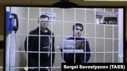 Two of the defendants, Vladimir Kalmykov (left) and Ishtimir Khudzhamov, take part in a virtual court hearing in Moscow. (file photo)