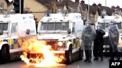 Violențele dintre autoritățile britanice și localnicii din zonă continuă în ciuda Acordului din Vinerea Mare, semnat în 1998. În această fotografie, flăcările cuprind un vehicul al poliției britanice, în timp ce ofițerii sunt atacați de tinerii naționaliști pe strada Springfield din Belfast, 8 aprilie 2021.