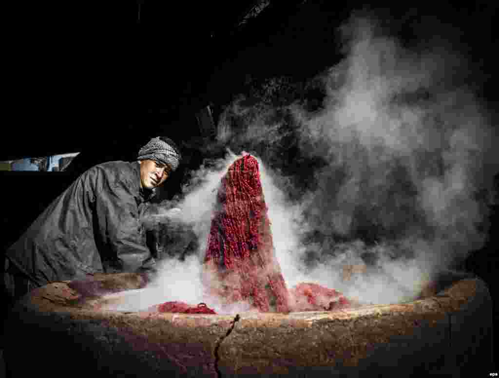 A man dyes threads to be used in weaving carpets at a factory in Kabul. (epa/Hedayatullah Amid)