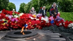 People lay flowers on the Tomb of the Unknown Soldier to mark Victory Day over Nazism in World War II, at the Eternal Glory park in Kyiv on May 9.