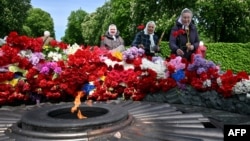 People lay flowers on the Tomb of the Unknown Soldier to mark Victory Day over Nazism in World War II, at the Eternal Glory park in Kyiv on May 9.