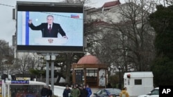 Në Sevastopol, në gadishullin ukrainas të okupuar të Krimesë, shihet një ekran televiziv që tregon presidentin rus, Vladimir Putin, gjatë fjalimit të tij vjetor për gjendjen e kombit.