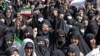 Iranians wave the national flag as they take part in a state-sponsored rally in Tehran on September 23. 