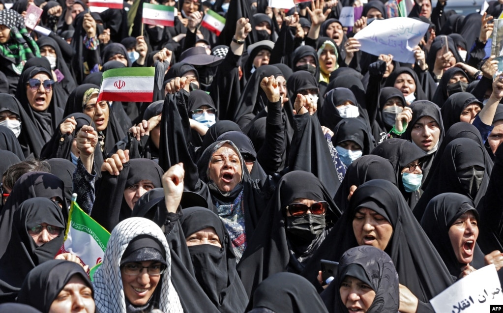 Gra iraniane duke mbajtur flamurin kombëtar gjatë një tubimi të thirrur nga shteti në Teheran më 23 shtator, me qëllim që t'u kundërpërgjigjen protestave antiqeveritare që po mbahen qe disa javë.