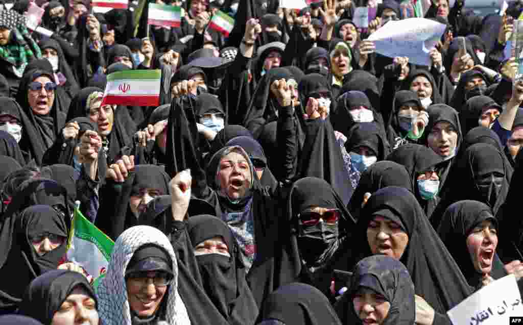 Iranians wave the national flag as they take part in a state-sponsored rally in Tehran on September 23 aimed at countering weeks of anti-government protests.&nbsp;