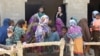 Angelina Jolie (in black) listens through a translator to women in Pakistan's Dadu district on September 20 after they were displaced by historic flooding that has deluged Pakistan since mid-June.