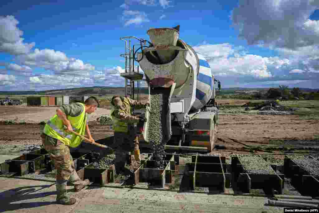 Workers pour concrete at a site that will be used as a vehicle maintenance area at the Cincu military training facility in central Romania. The images in this gallery were taken on September 20, and show NATO&#39;s work to massively expand the military training area near the Romanian village of Cincu as Russia&#39;s invasion of Ukraine grinds on. &nbsp;