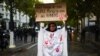  Učesnica protesta drži transparent sa natpisom "Ovo je slika mog naroda. Prenesite glas Iranaca", dok stoji ispred kordona policije tokom demonstracija podrške iranskim demonstrantima. U Parizu, 25. septembra 2022.