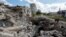 Local residents stand next to the debris of a destroyed building in Lysychansk on September 21.
