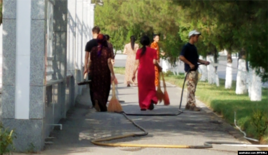Ашхабад. Молодые люди, вышедшие на субботник, чистят дорожки. В последние десятилетия в Туркменистане проводится много субботников (ёвар) и участие в них для населения носит принудительный характер.&nbsp;