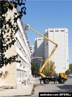 Dört ýyl ozal senesi üýtgedilen garaşsyzlyk baýramçylygyna taýýaryk işleriniň çäklerinde, köpgatly jaýlaryň köçeden görünýän tarapy ak reňke boýalýar. Sentýabr, 2022 ý. Aşgabat ş. Türkmenistan.