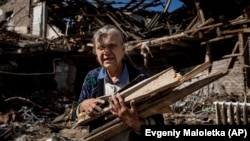 A woman collects wood for heating from a destroyed school in the Izyum area, which was recently recaptured by Ukraine. Massive Russian missile strikes targeting the country’s civilian heating infrastructure means that many Ukrainians could be in for a cold winter this year. 