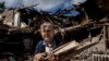 Fűtéshez fát gyűjtő asszony egy lerombolt iskola romjai között Izjum közelében 2022. szeptember 19-én