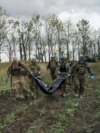 Оваа фотографија, на која се прикажани припадници на украинската национална гарда како го извлекуваат телото на војник во регионот Харкив, е една од неколкуте направени на 17 и 19 септември од фоторепортерот на АП, Лео Кореа.<br />
<br />
Фотографот&nbsp;се приклучи на ризичната мисија за враќање на посмртните останки на украинските борци од поранешните боишта кои неодамна беа повторно преземени од украинските сили.