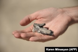 A person holds a fragment of shrapnel in Sotk on September 14.