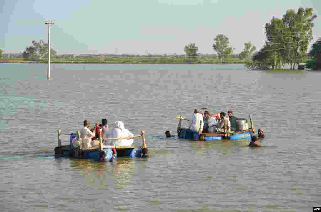 People on makeshift rafts are pulled across floodwaters in the Jaffarabad district on September 18.&nbsp; The World Health Organization says a surge in sickness as a result of the flooding has the potential to become a &quot;second disaster.&quot; &nbsp;