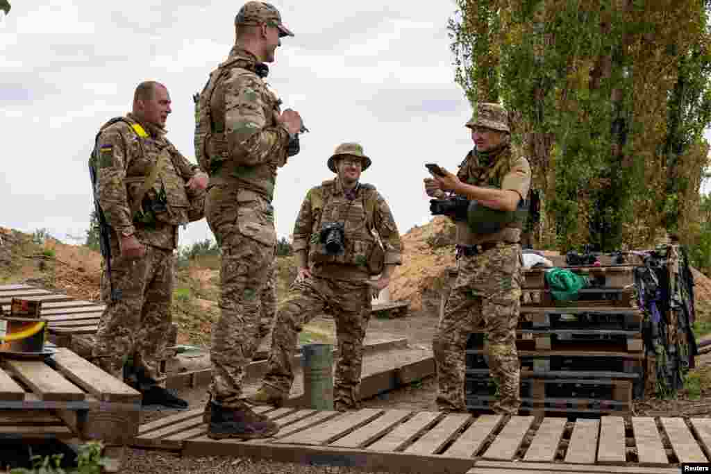 A newly recruited volunteer, Steve Andre, a 37-year-old from Detroit, Michigan, chats with his comrades while working&nbsp; as a photographer with a Ukrainian brigade at a position near a front line in the Mykolayiv region.