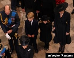 Prințul William, Prințesa Kate Middleton și cei doi copii ai cuplului regal, Prințul George și Prințesa Charlotte, în timpul funeraliilor de stat organizate în memoria bunicii Prințului William și a străbunicii lui George și Charlotte, Regina Elisabeta a II-a.