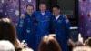 NASA astronaut Frank Rubio (right) and Russian cosmonauts Sergei Prokopyev (center) and Dmitry Petelin pose in front of a bus while leaving a hotel for prelaunch preparations on September 21.