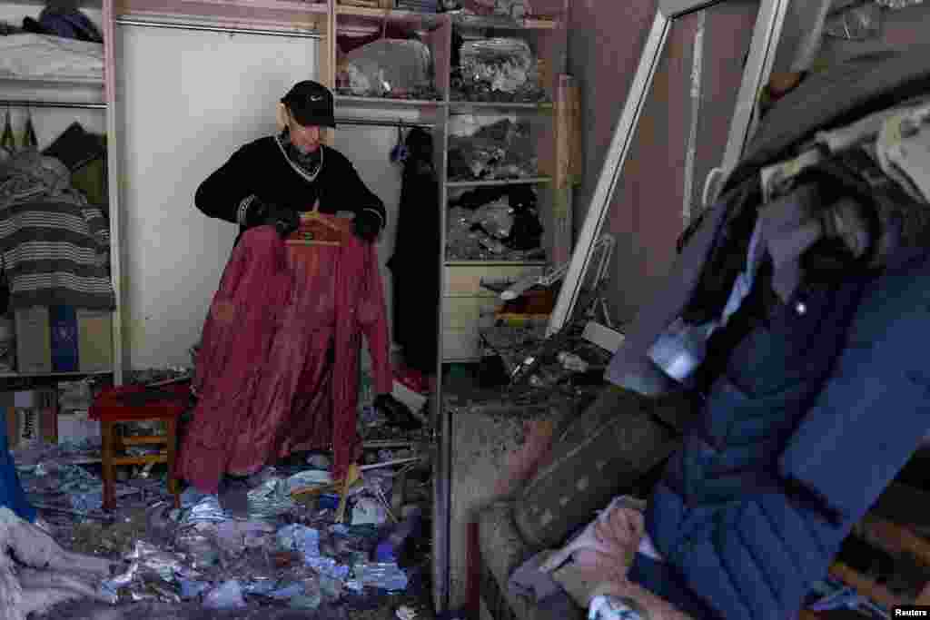 A man collects belongings from a damaged apartment building in Mykolayiv.