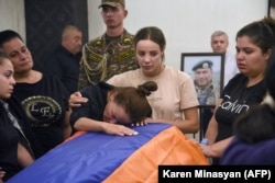 Relatives mourn at the coffin of an Armenian soldier killed during the recent clashes. The photo was taken in Yerevan on September 16.