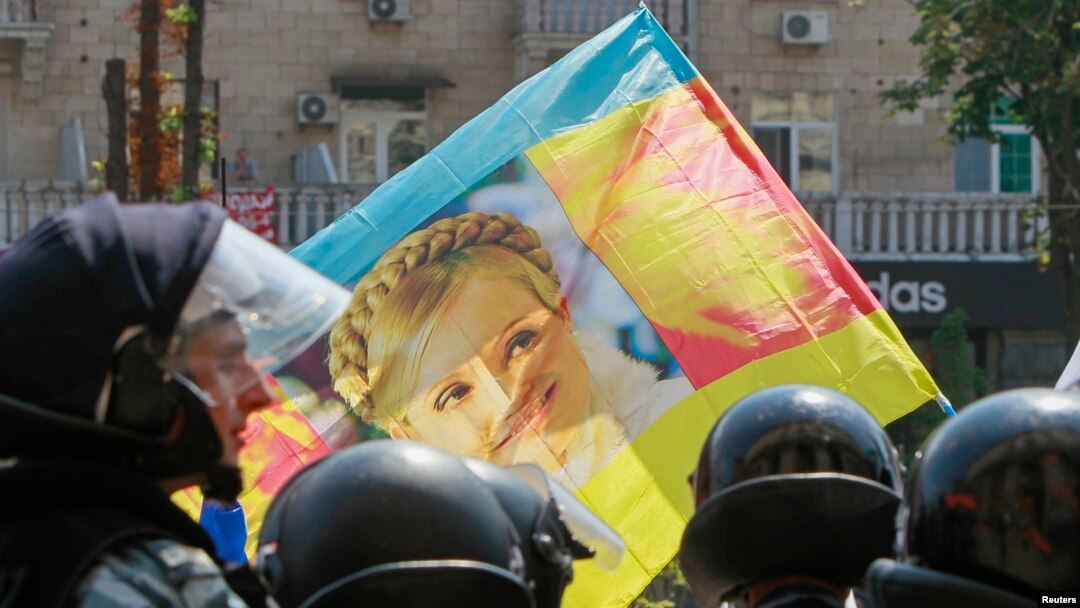 Ukrainian riot police block opposition supporters carrying a flag with the portrait of jailed former Prime Minister Yulia Tymoshenko from entering the city hall during a rally in Kyiv in July.