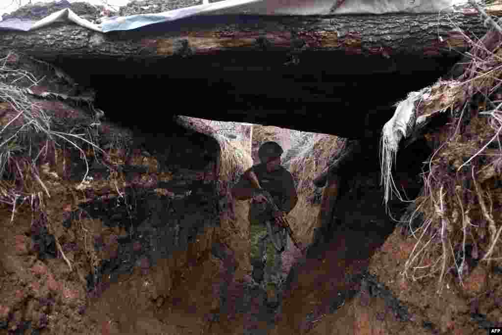 A Ukrainian soldier patrols in a trench near Avdiyivka.