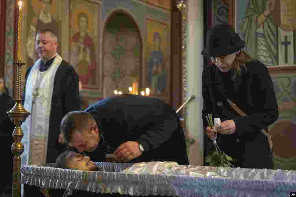 The parents of Polish volunteer soldier Filip Antosiak, 18, who served in the 25th Separate Airborne Brigade of the Armed Forces of Ukraine, grieve at his funeral at St. Michael&#39;s Monastery in Kyiv.