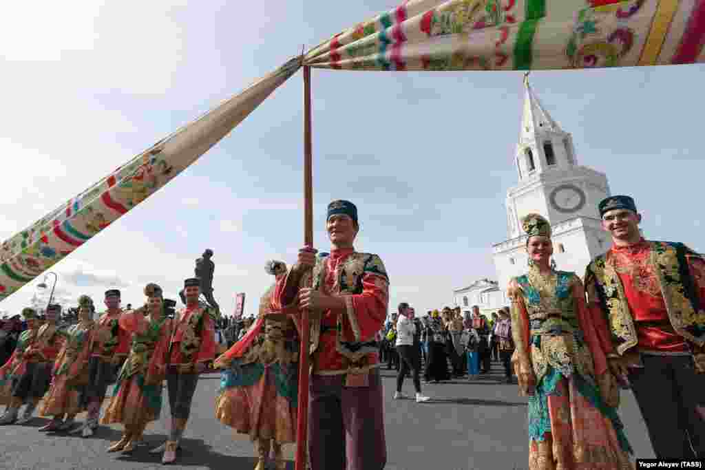 Артисты выступают в традиционных костюмах во время торжества.