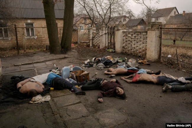 The bodies of Bucha residents, all dressed in civilian clothes, some with their hands tied behind their backs, lie on the ground on April 3.