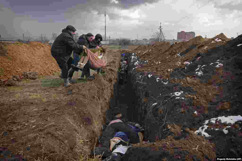 Trupat e viktimave vendosen në një varr masiv në periferi të Mariupolit më 9 mars. Qyteti-port pësoi një shkatërrim të gjerë gjatë një rrethimi gati tremujor ku u vranë mijëra civilë.